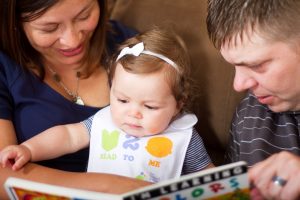 Parents Reading to Girl Toddler